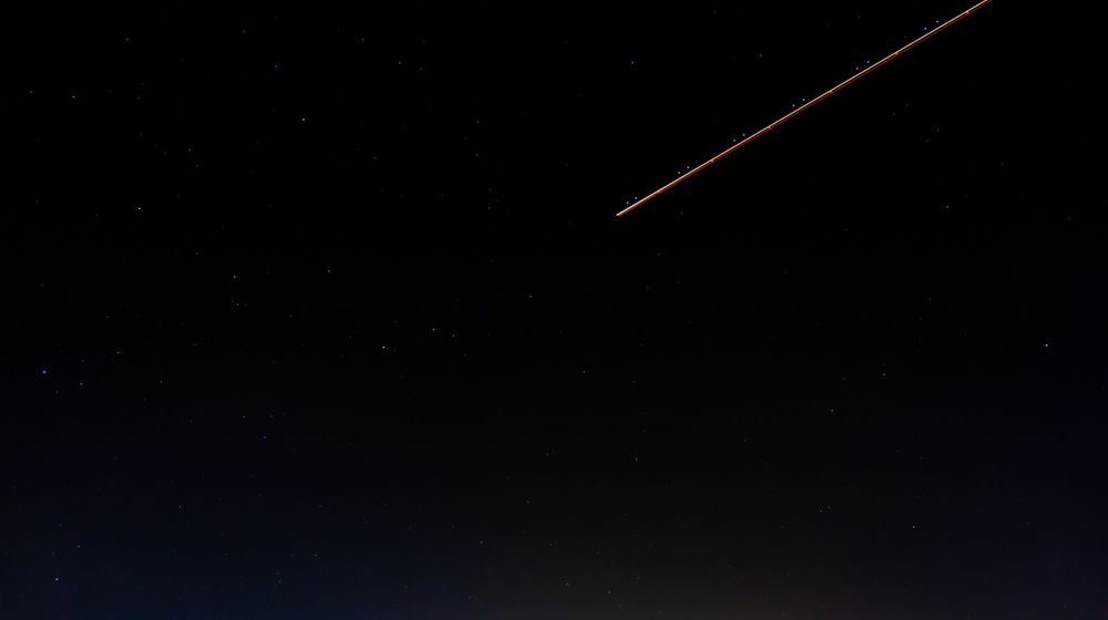 Étoile filante traversant un ciel nocturne pendant une pluie de météores