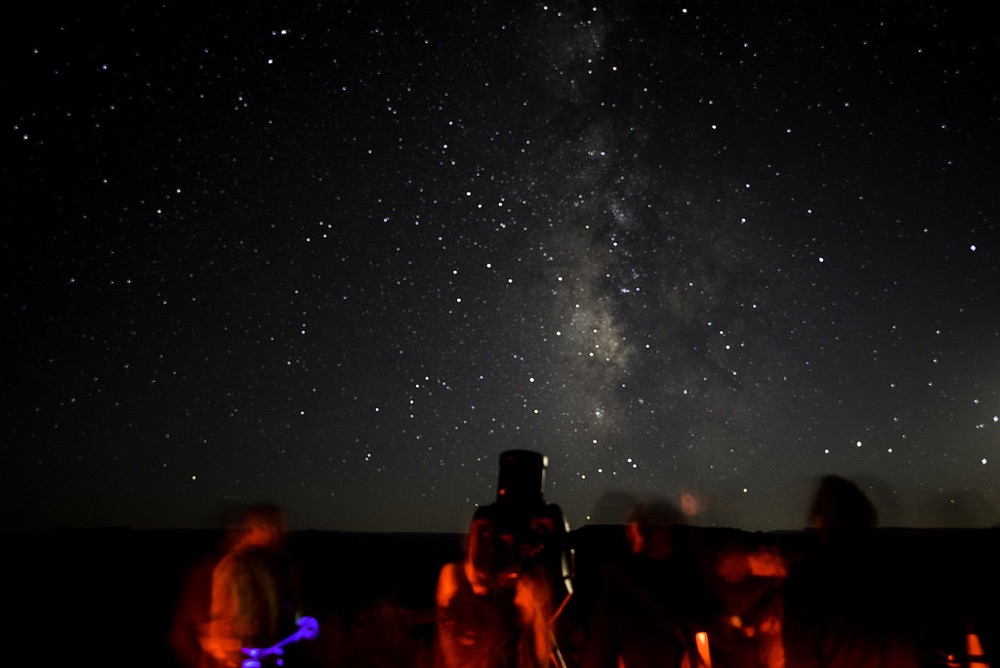 Observateurs et instrument d'astronomie sous la Voie lactée, lors d'une soirée consacrée aux lunettes astronomiques