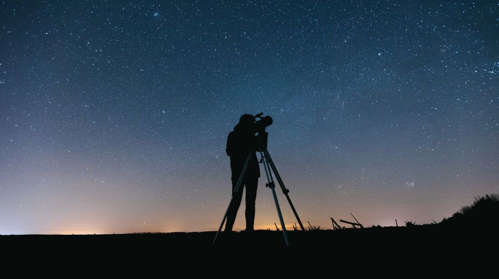 Télescope Dobson sur son socle pivotant, pointé vers le ciel étoilé au crépuscule